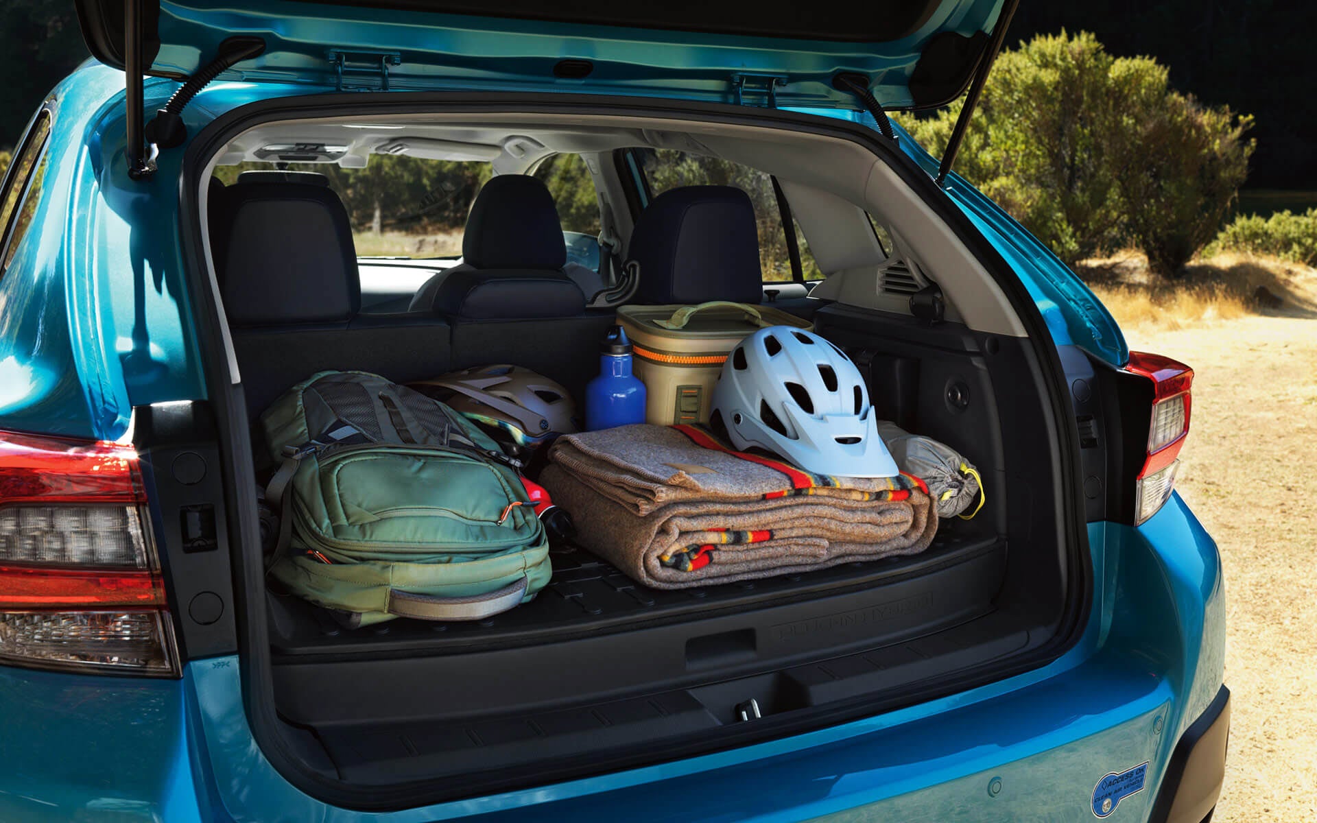 A backpack, blanket, and bike helmet in the rear cargo area of a Crosstrek Hybrid | Neil Huffman Subaru in Louisville KY
