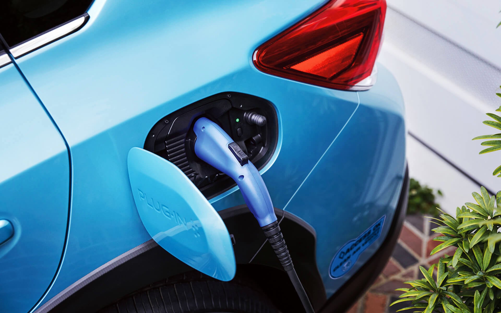 A close-up of the Subaru Crosstrek Hybrid's charging port with charging cable plugged in | Neil Huffman Subaru in Louisville KY